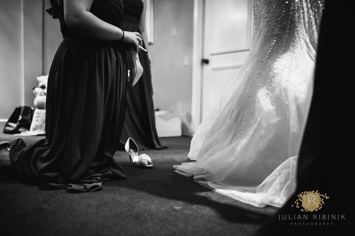 Bridesmaid helps the bride put on the wedding sandals