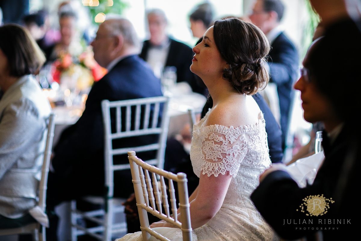 The bride looks on while guests dance