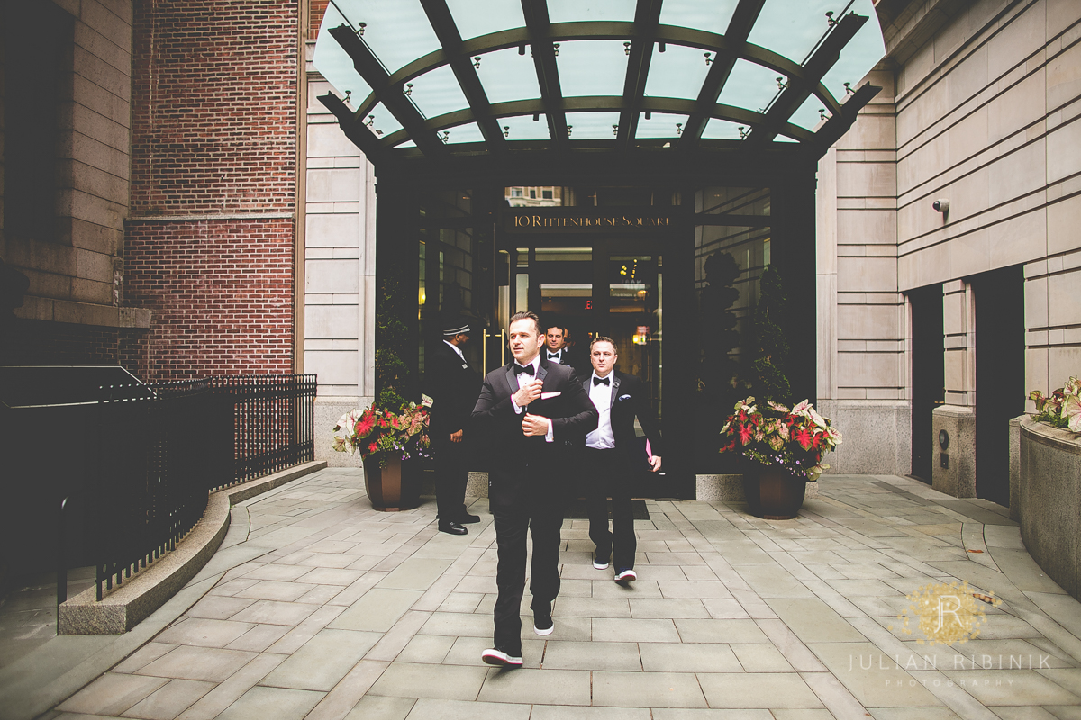 The groom and groomsmen coming out of a hotel in Philadelphia