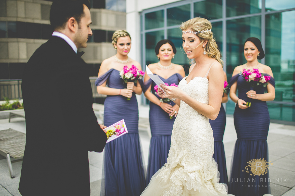 Bride reads to the groom while the bridesmaids watch