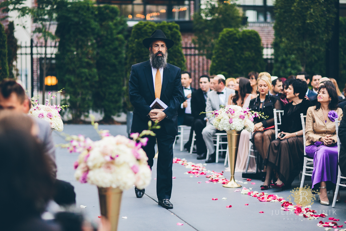 Jewish priest walks to the stage as wedding guest look on
