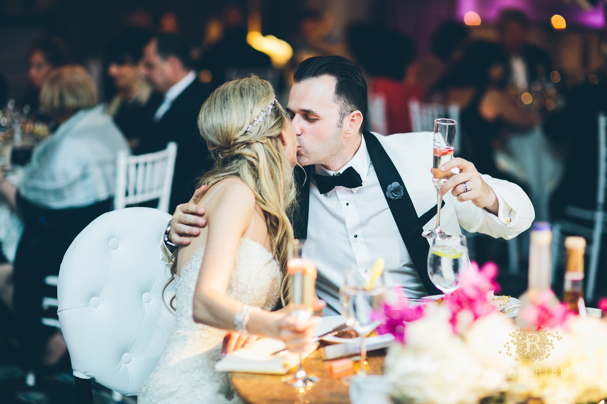Bride and groom a have kiss at the dinner table