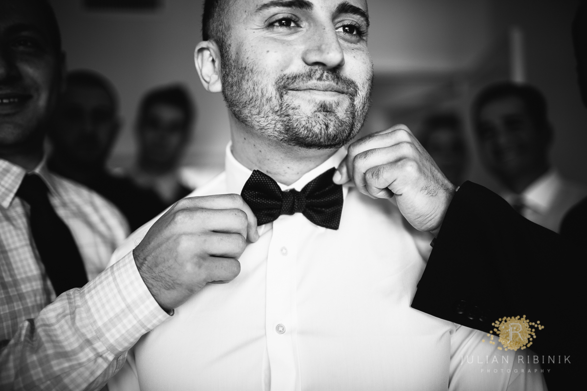 A black and white shot of groom with bow tie