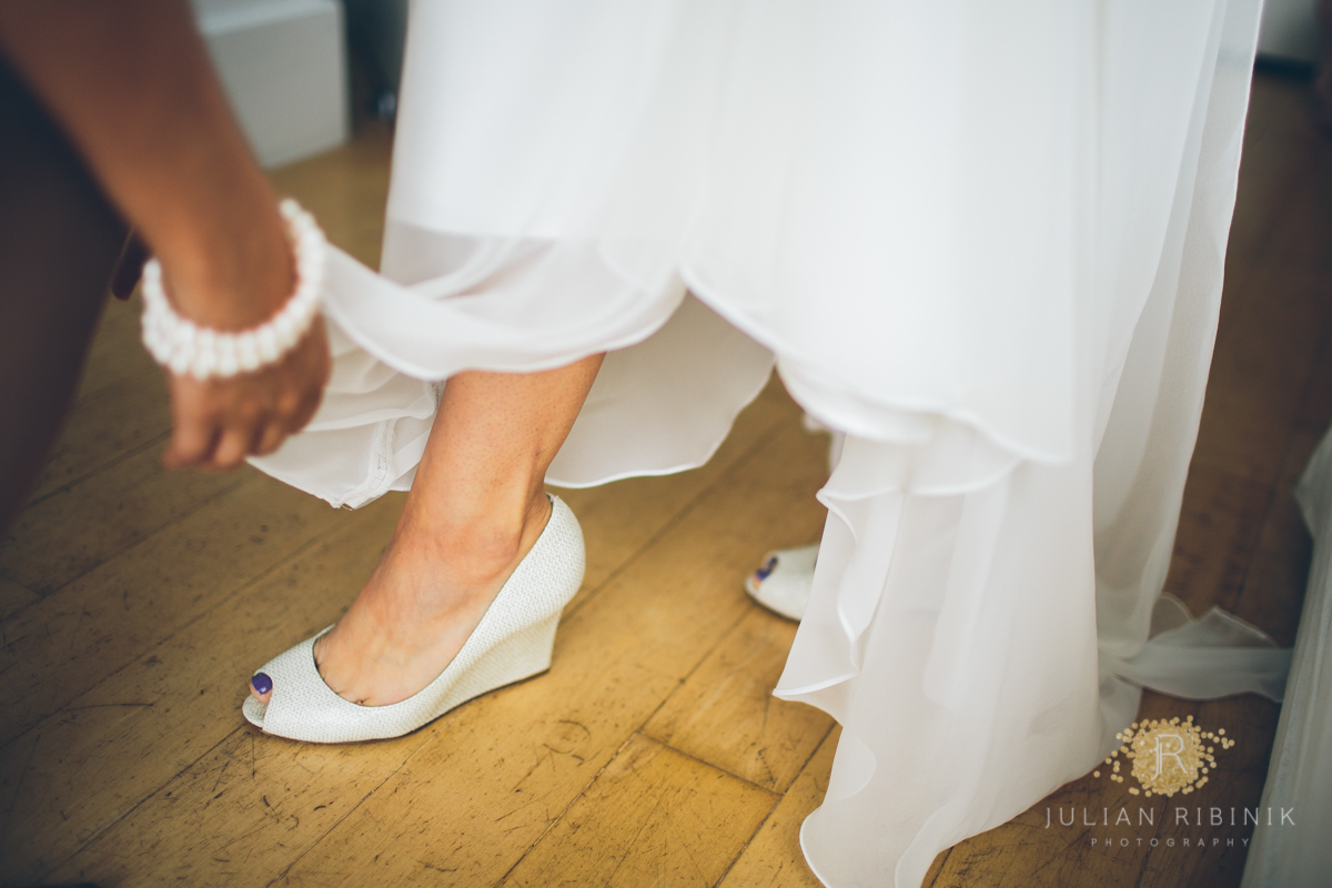 The bride wearing her wedding shoes