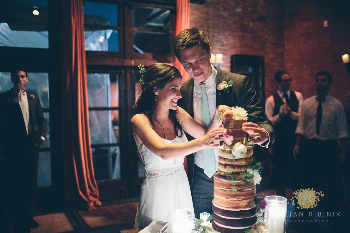 The bride and groom have a look at the beautiful wedding cake