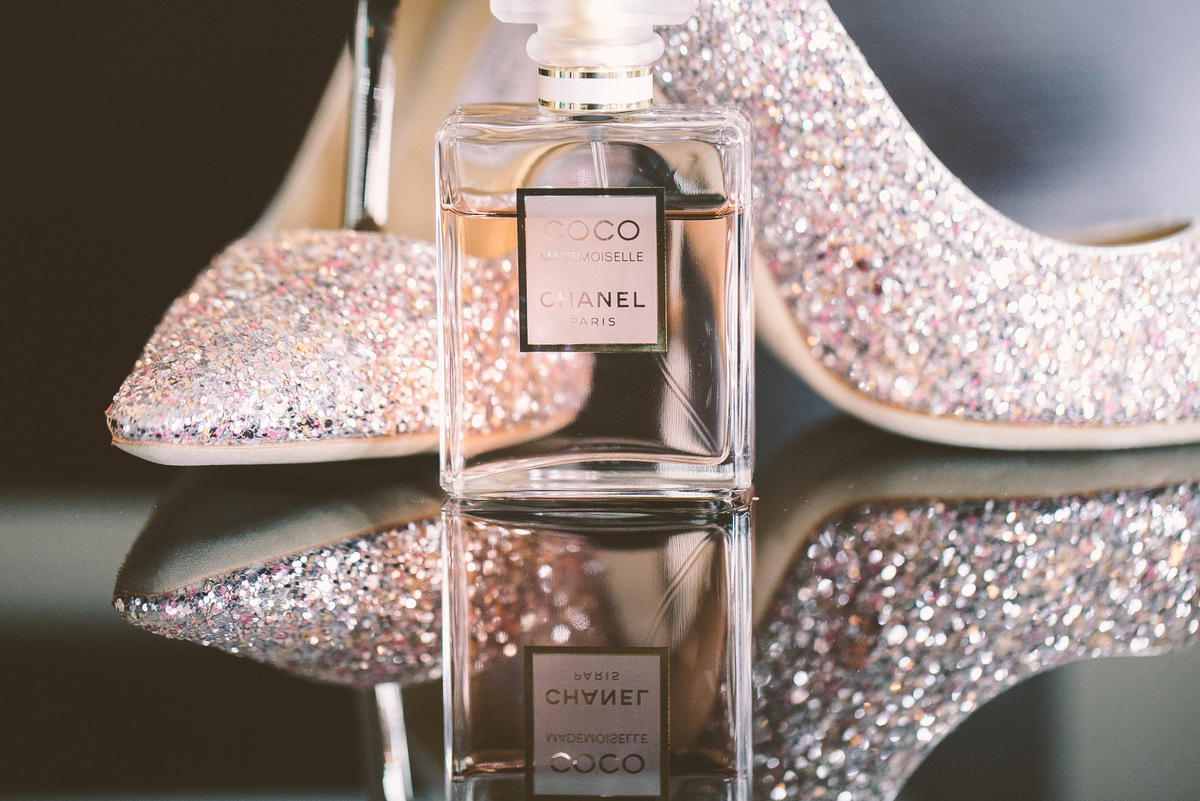 A bottle of Coco Chanel perfume next to Jimmy Choo heels