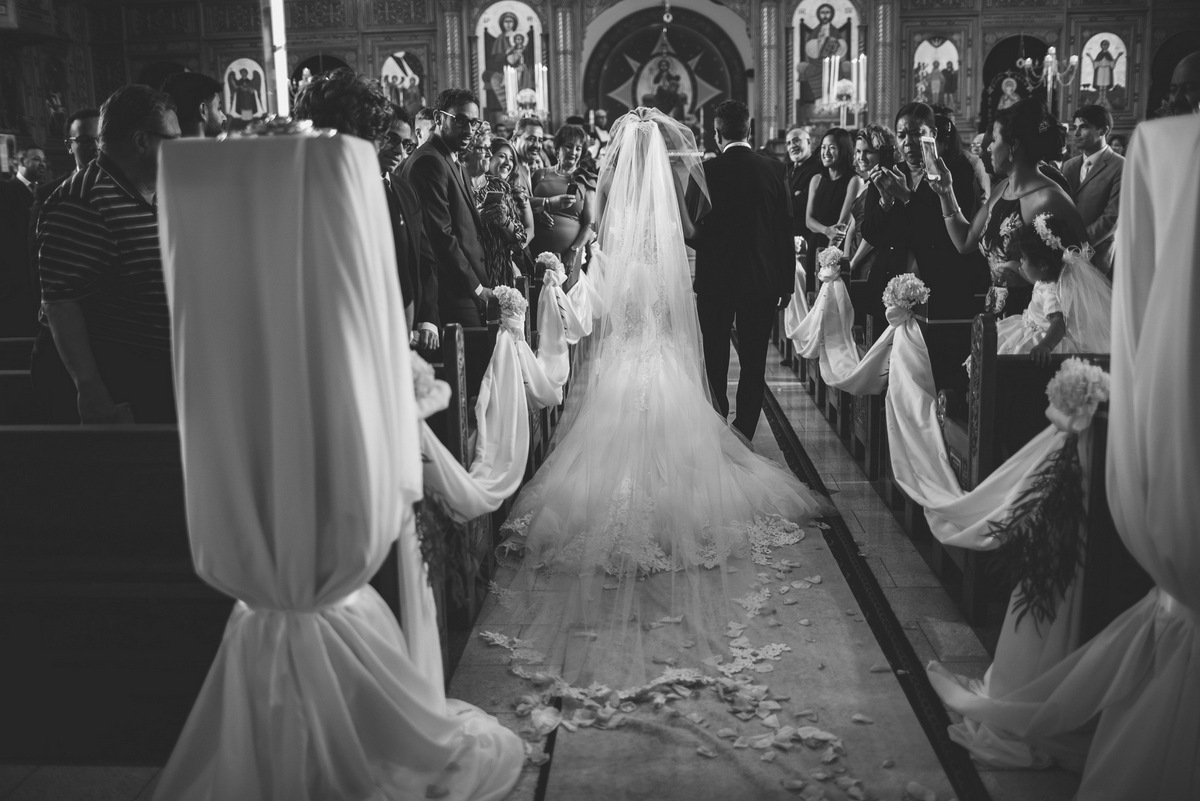 A black and white image of the bride walking down the aisle with her father