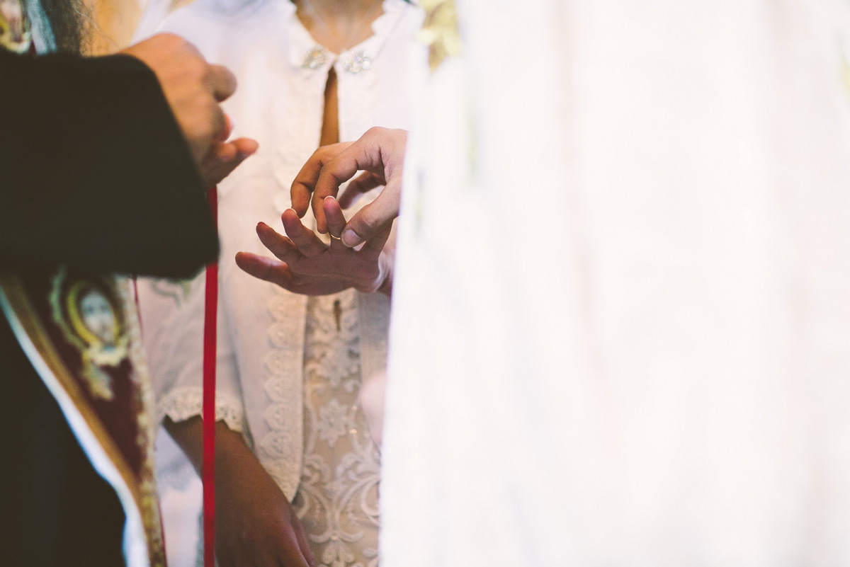 The groom slips the wedding ring on the bride's finger