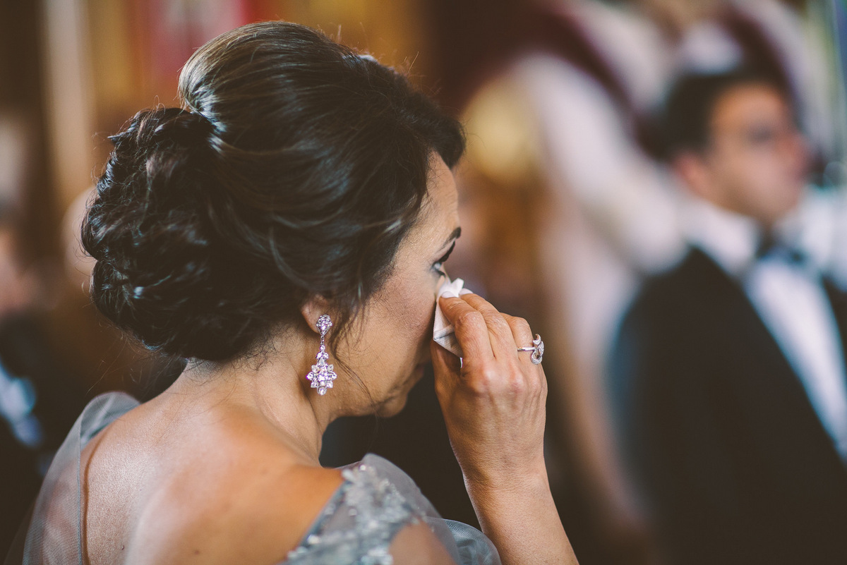 The bride's mother wipes away a tear