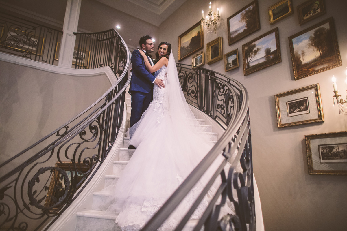 The bride and groom posing on a spiral staircase