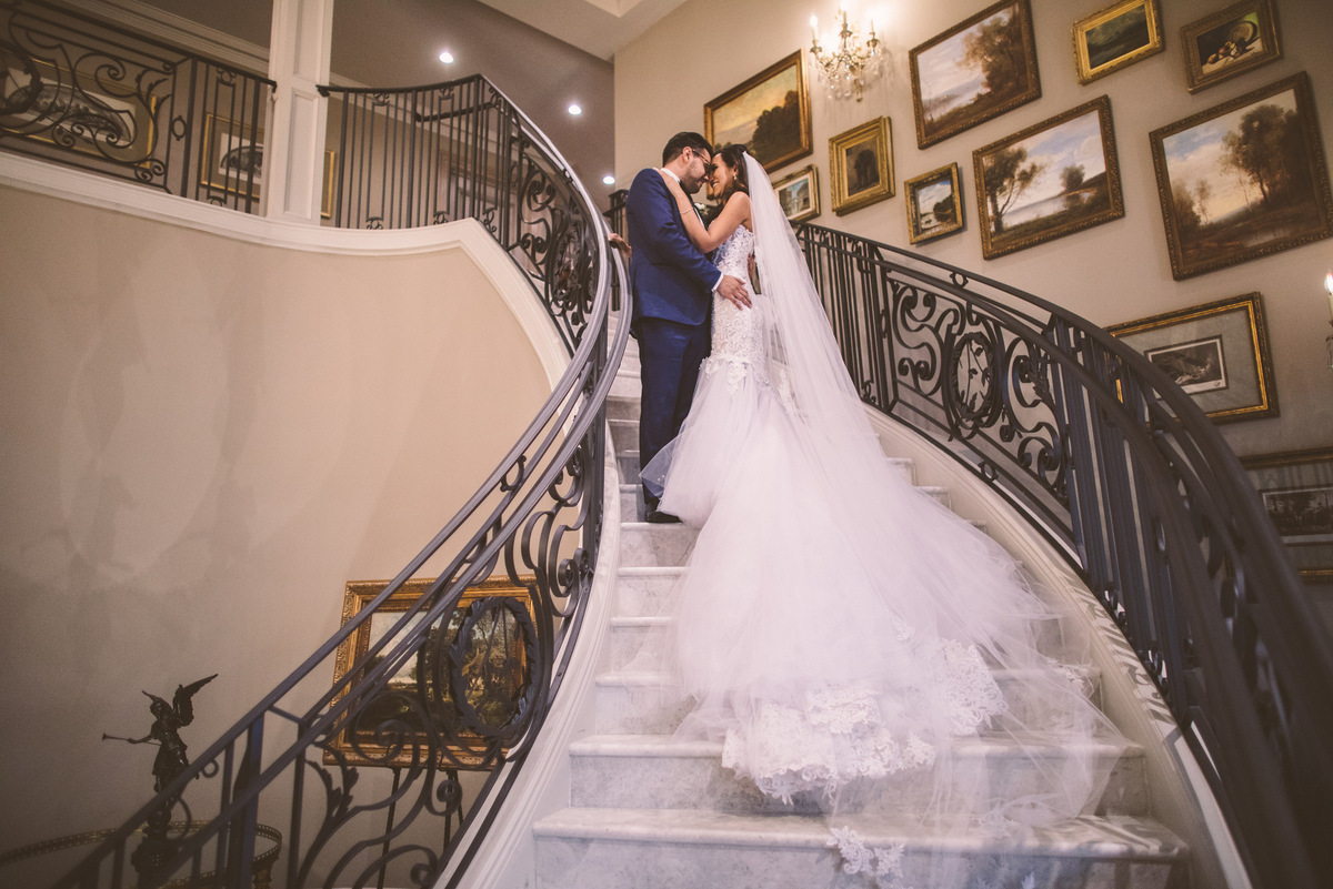 The bride and groom kiss on the staircase