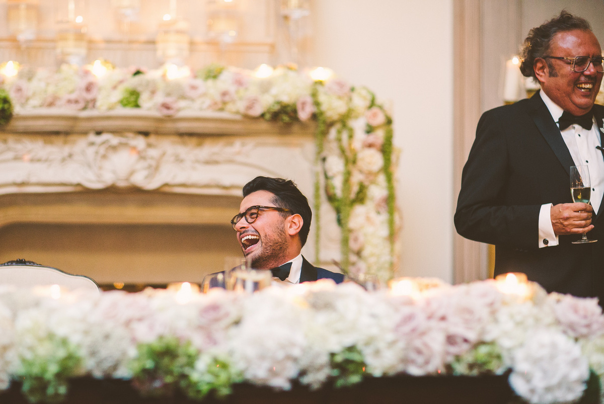 The groom laughs during the toast