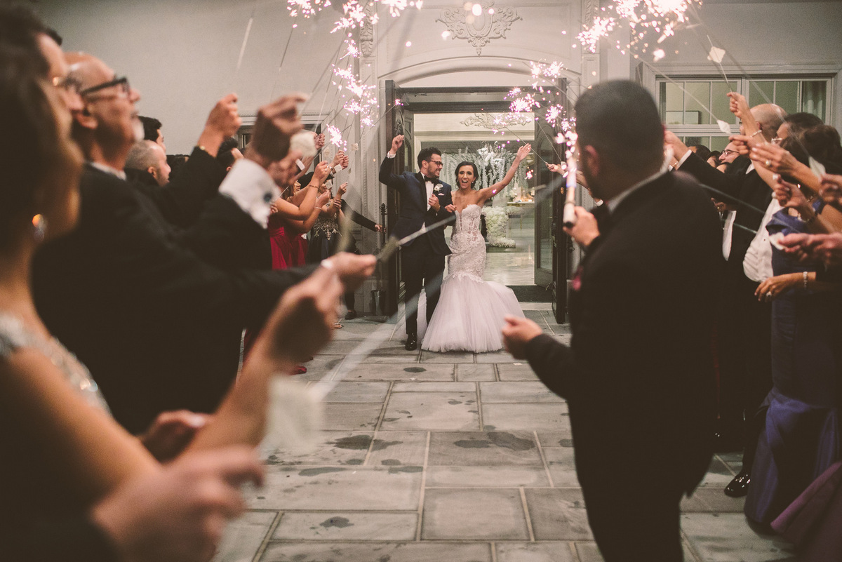 Guests hold sparklers as the bride and groom leave the reception