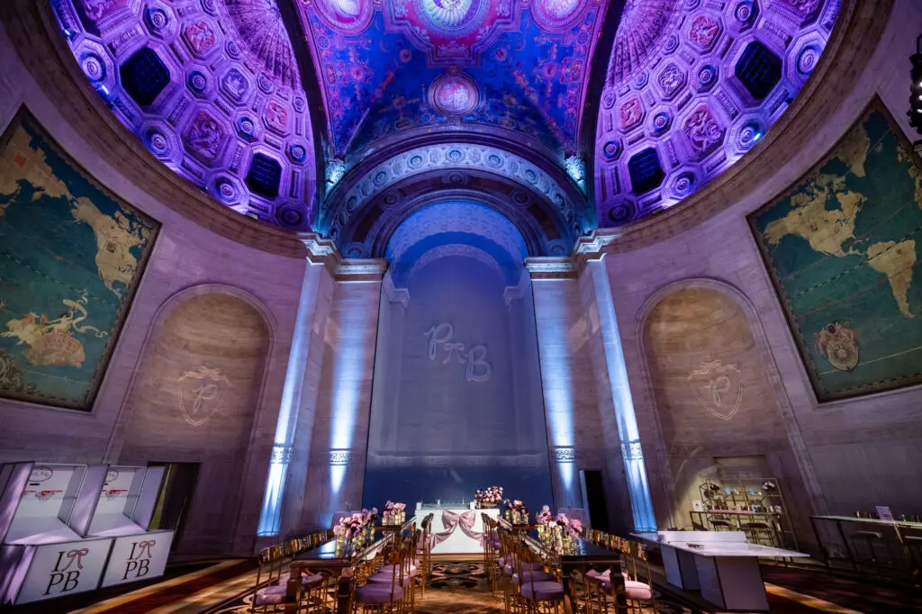 Bat Mitzvah reception setup in the Great Hall at Cipriani 25 Broadway, painted vaulted ceiling with purple and blue uplighting