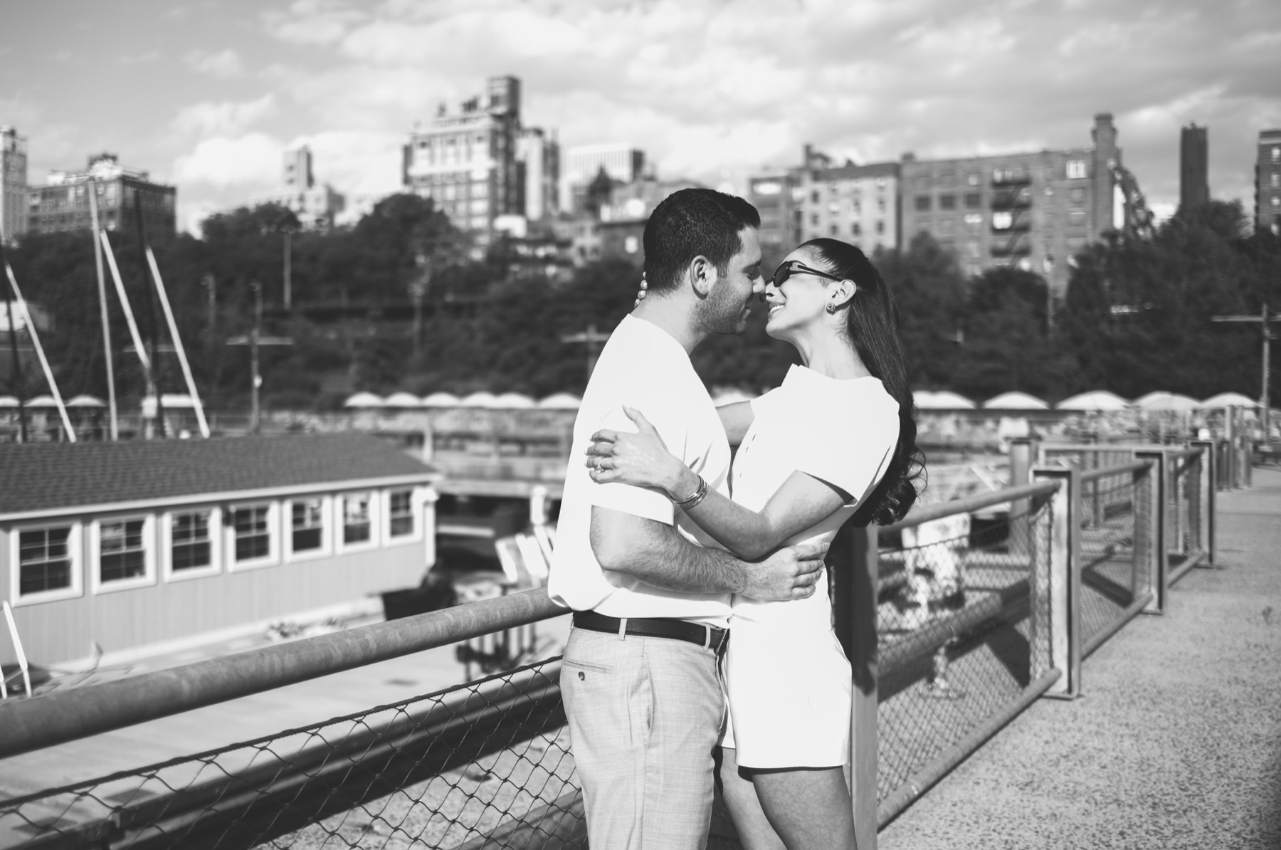 Couple kissing beside the East River with the Manhattan skyline in the distance