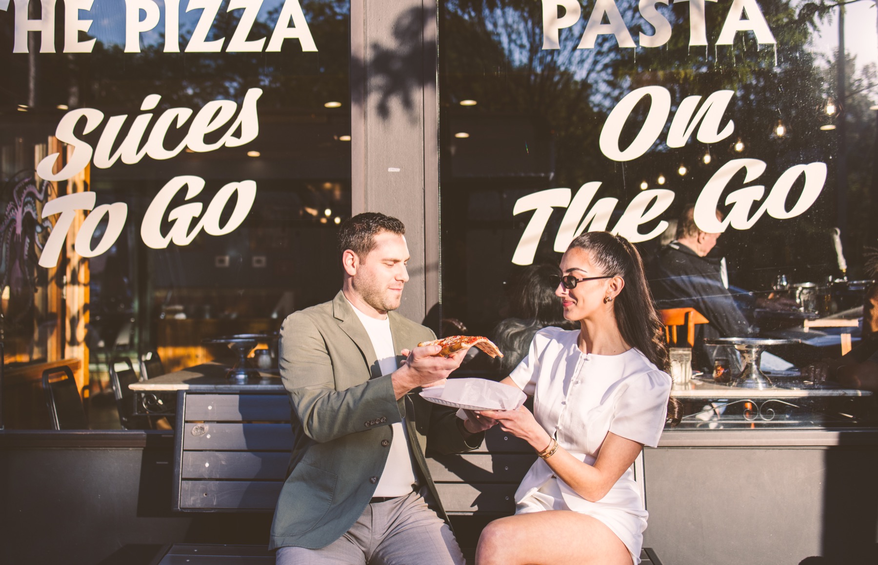 Couple sharing pizza outside a New York slice shop.
