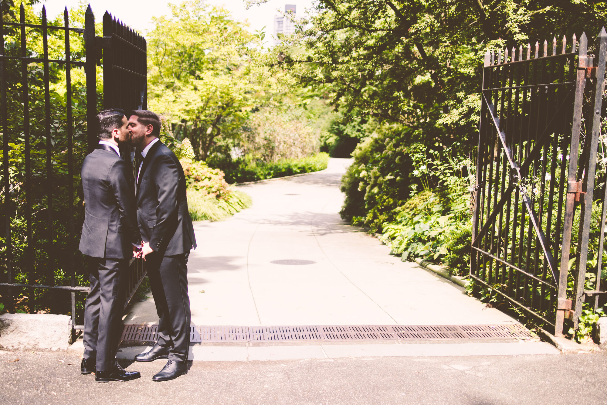 Two grooms embracing during their first look in a Manhattan park