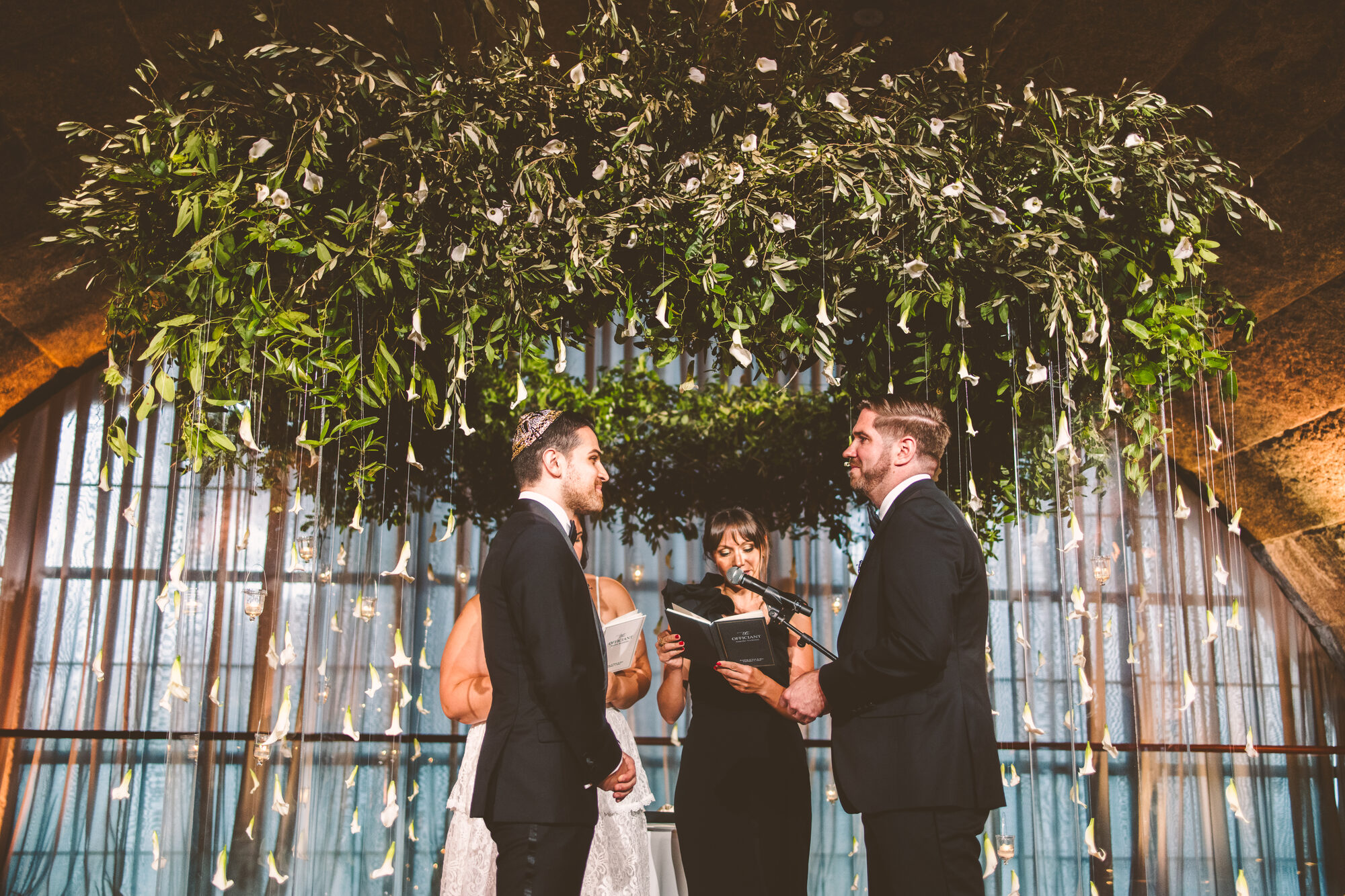 The couple under the greenery chuppah during their Guastavino's ceremony