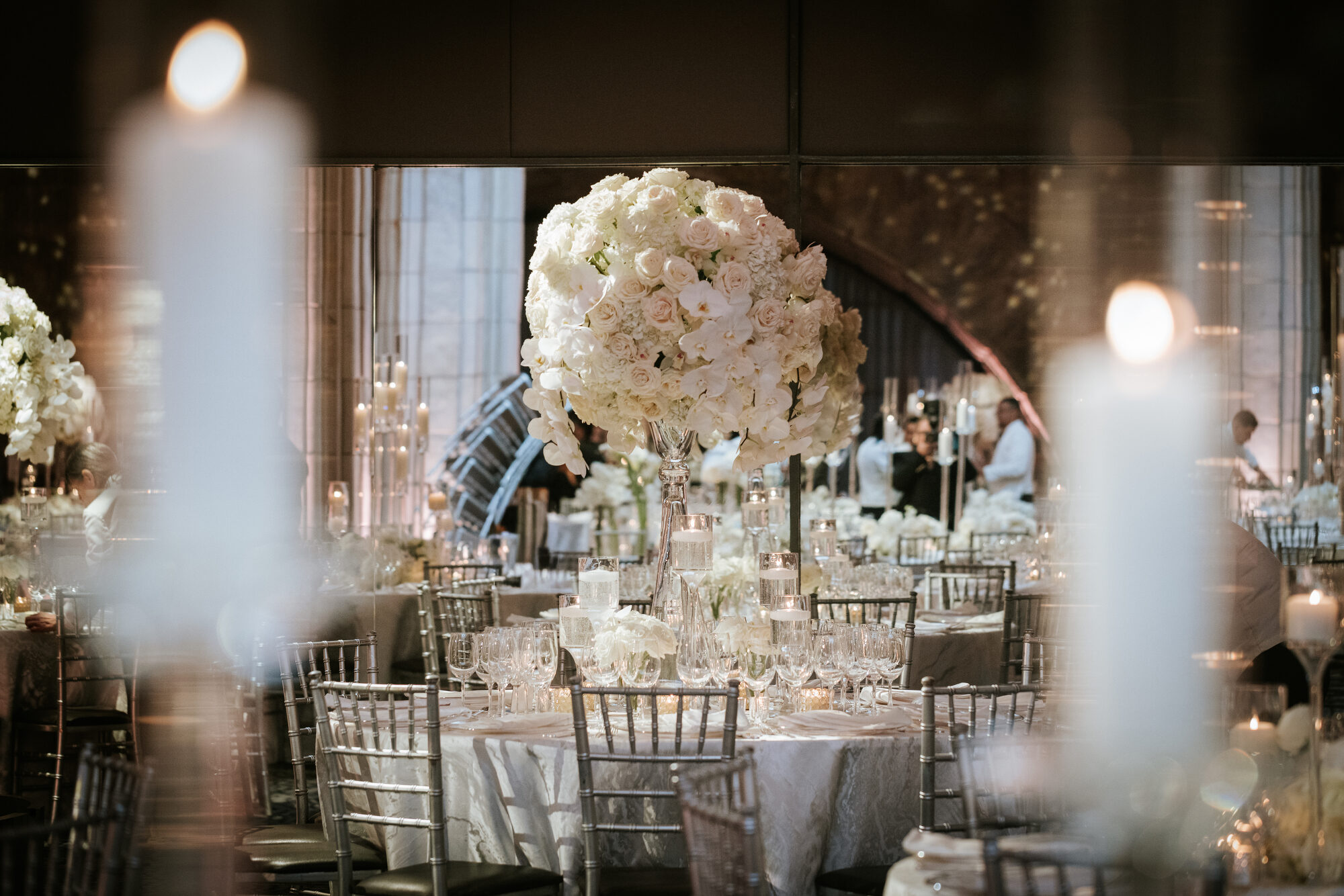 Long banquet table with white flowers and taper candles