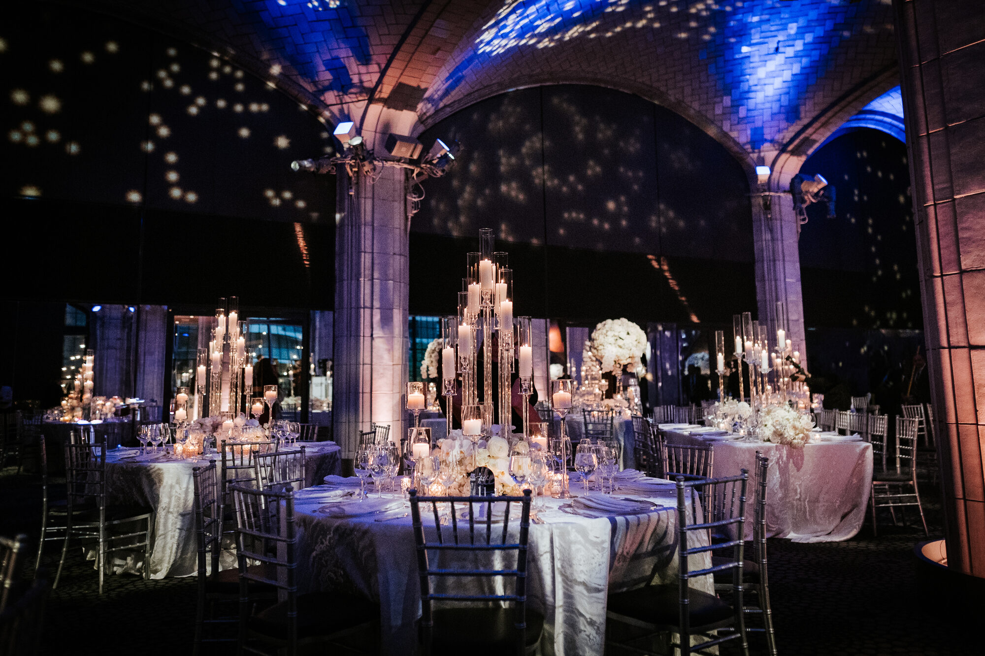 Wedding reception room glowing with warm uplighting