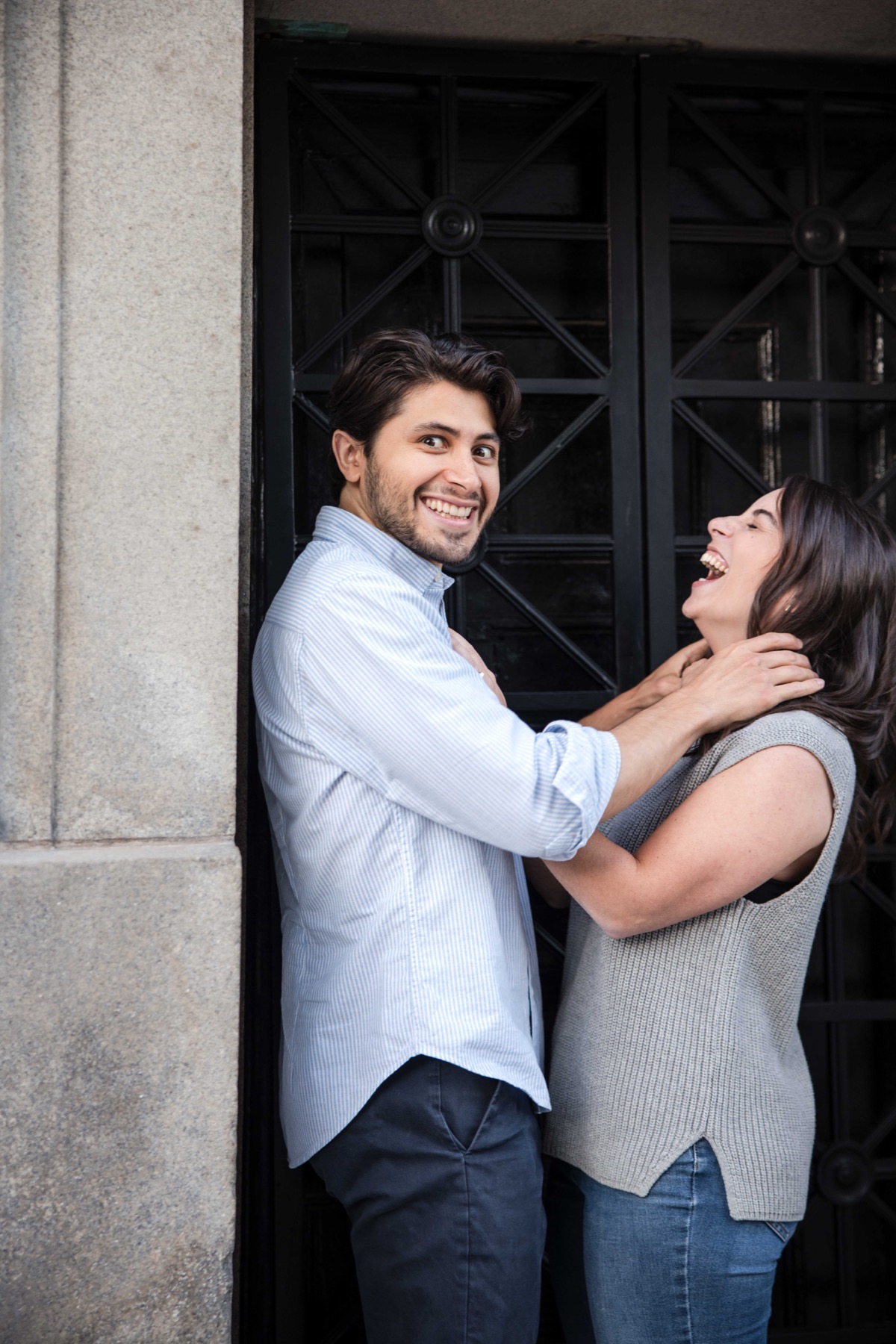 Couple laughing together beneath a stone archway in Prospect Park.