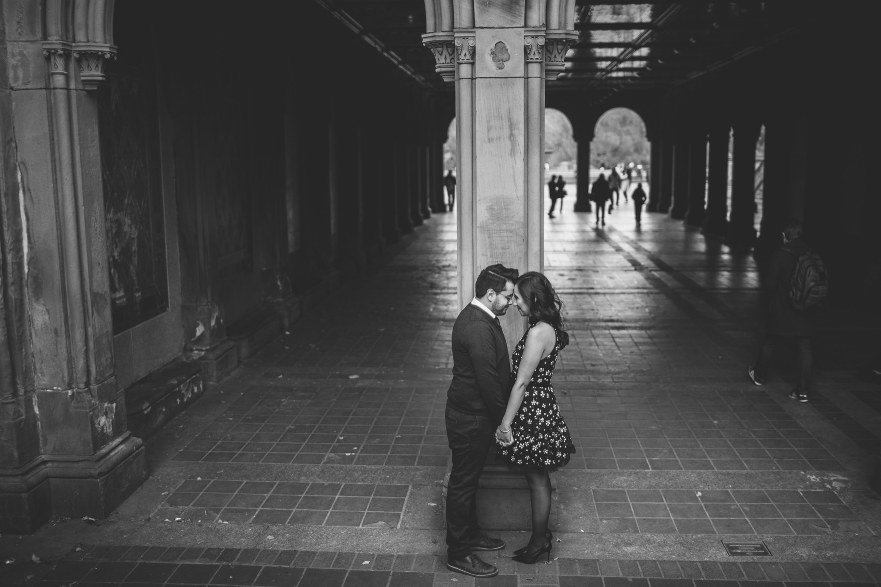 Black-and-white engagement portrait beneath the arches of Bethesda Terrace in Central Park