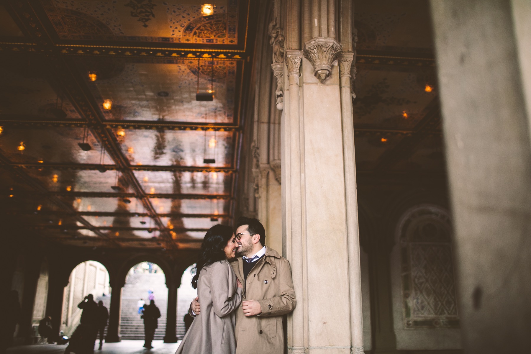 Couple laughing beneath the ornate ceiling of the Bethesda Terrace arcade in Central Park