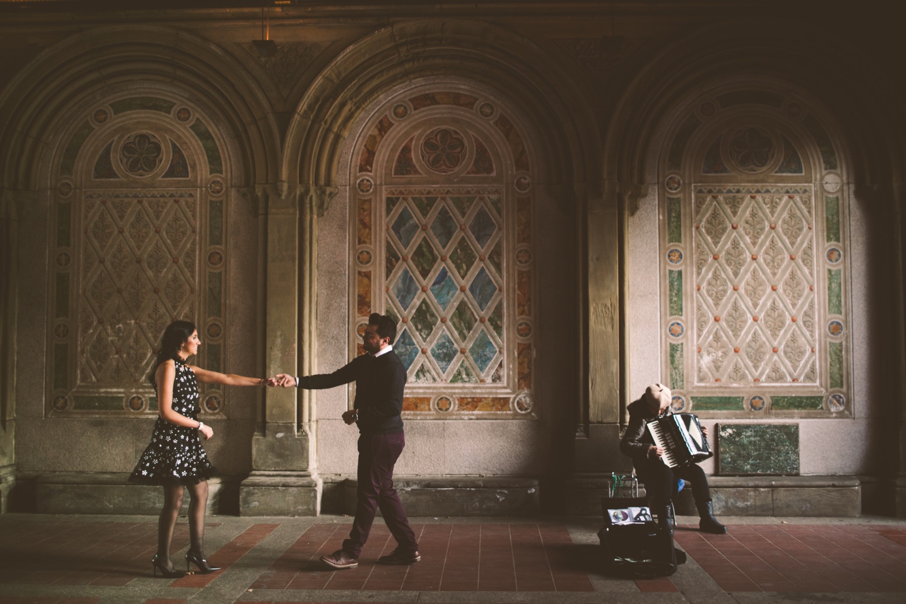 Couple dancing beside the tiled walls of Bethesda Terrace during their Central Park engagement session
