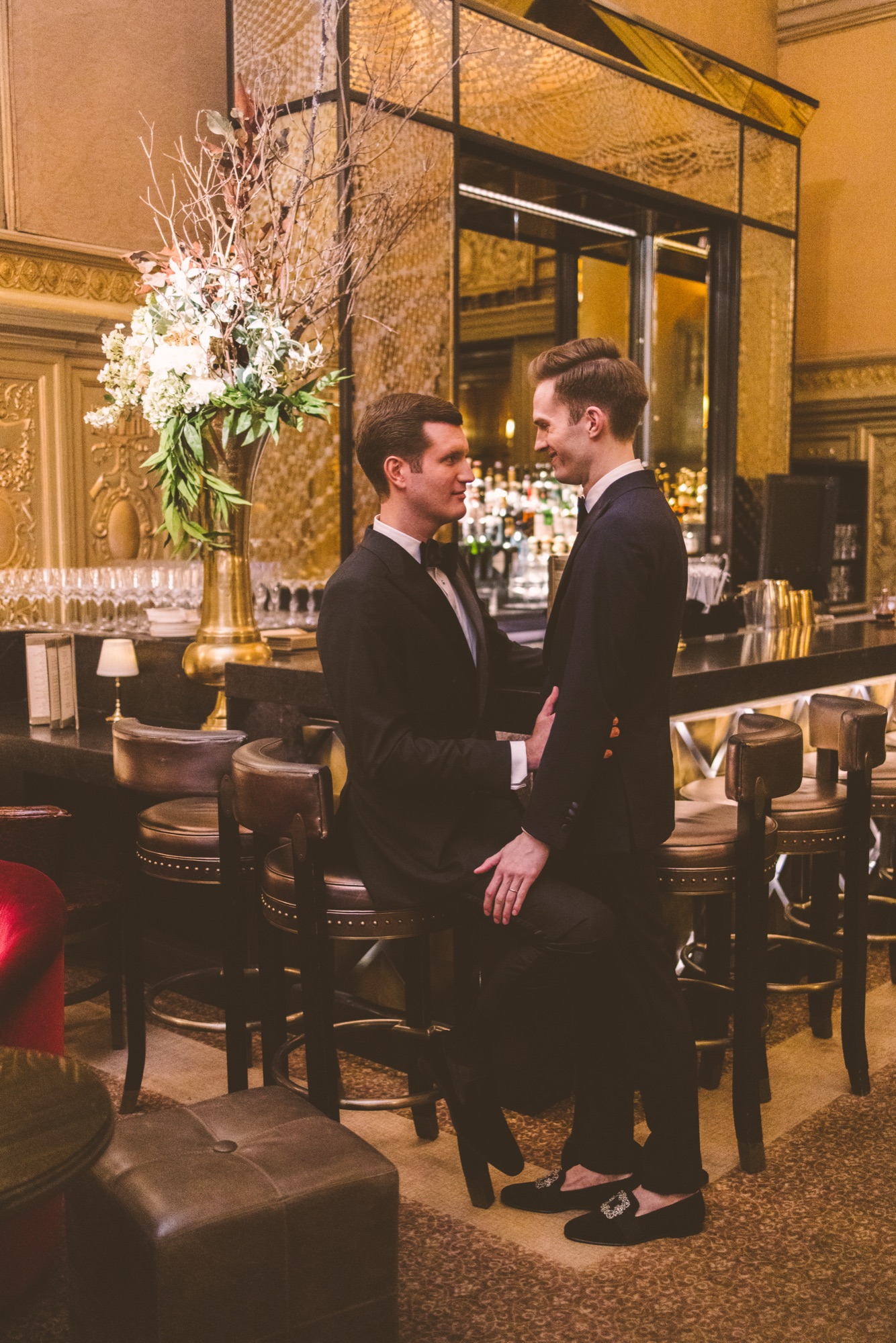A couple in a lounge hung with chandeliers and white florals