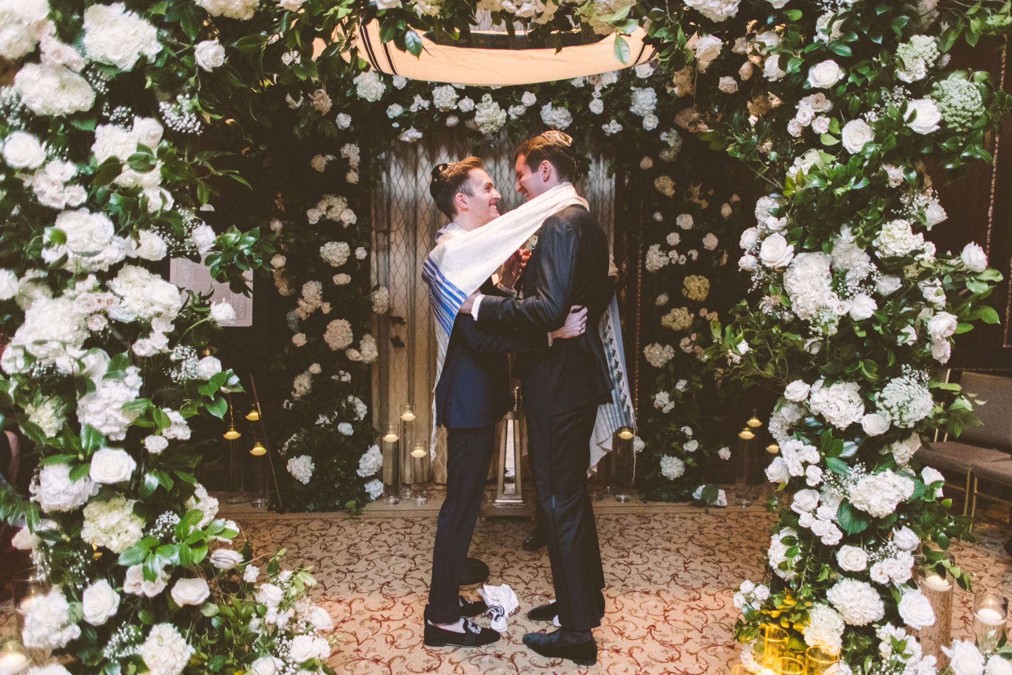A couple embracing under the chuppah after breaking the glass at the Lotte New York Palace