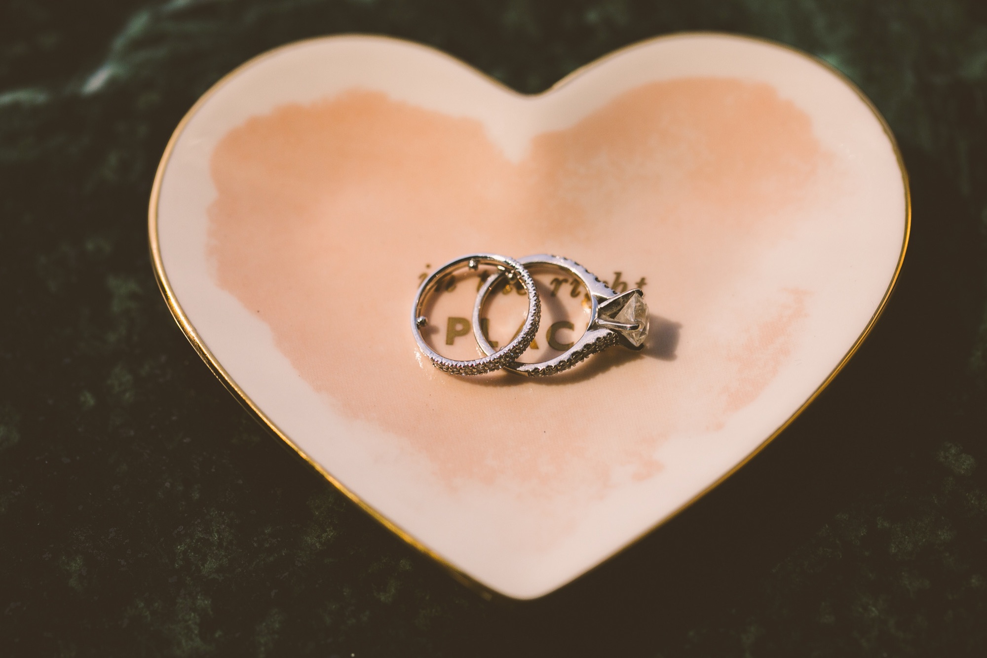 Two wedding bands in a pink ceramic heart dish