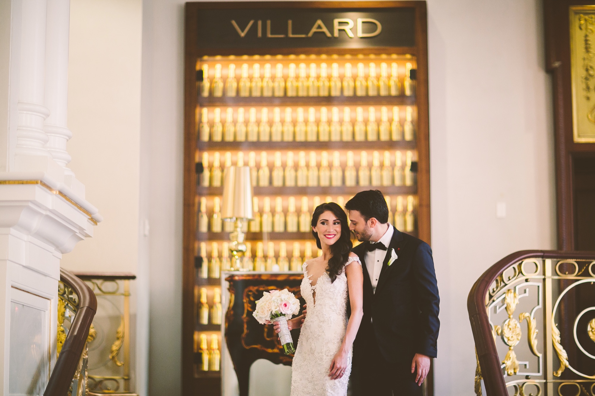A couple beside the bottle display beneath the Villard bar sign