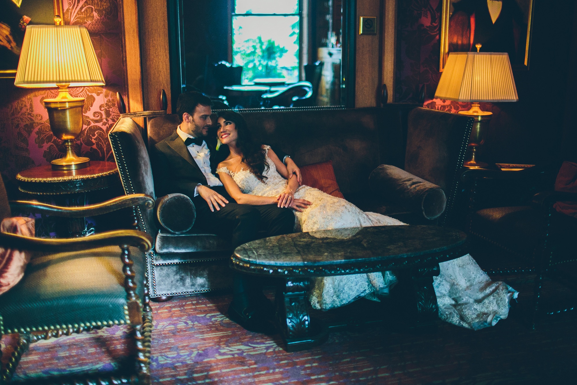 A couple in a richly coloured lounge lit by table lamps