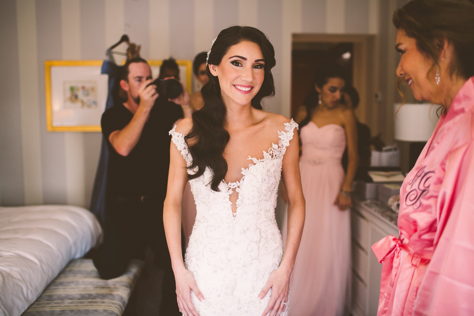 Final preparations to a lace wedding dress in the hotel suite