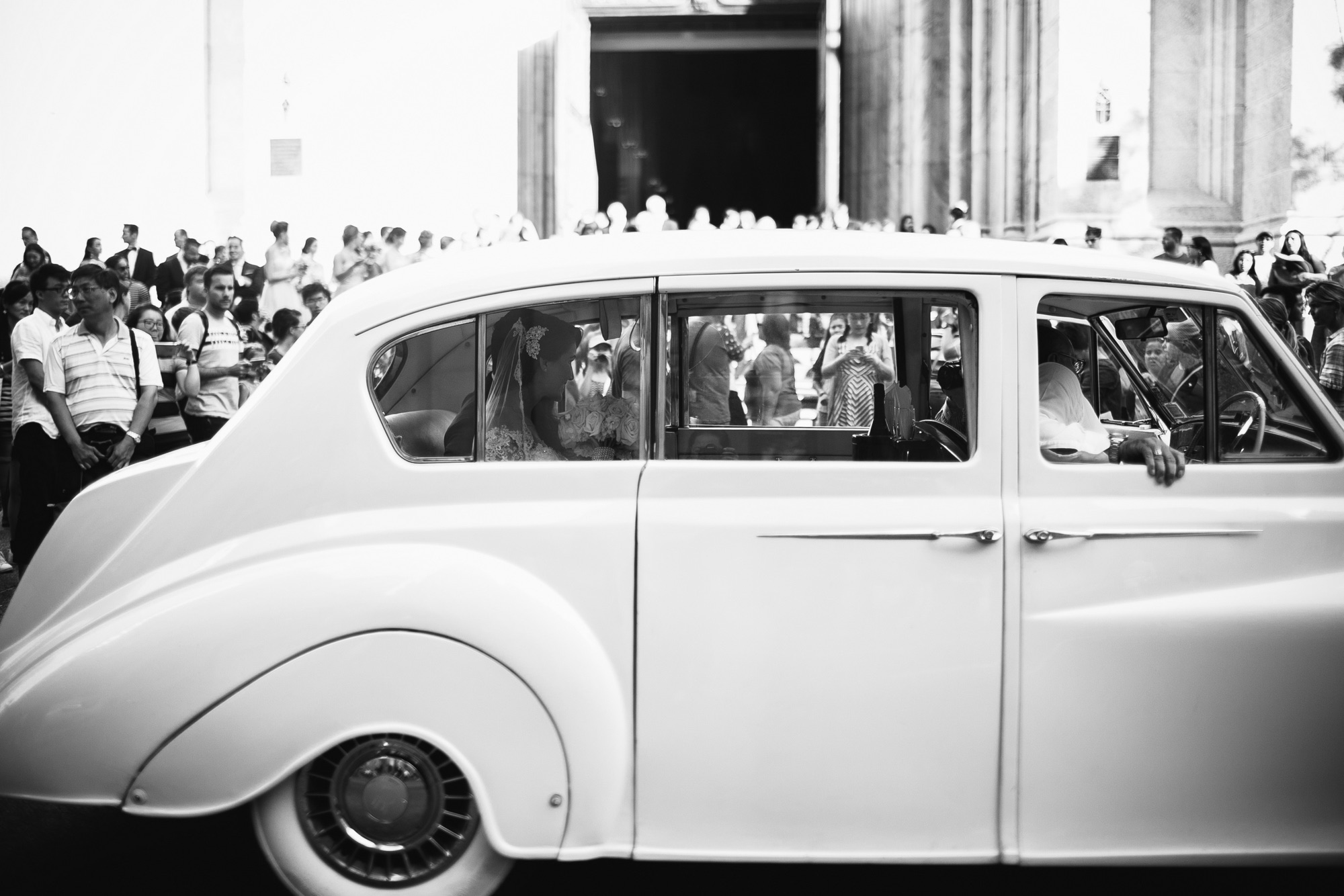 A vintage white Rolls-Royce waiting outside the cathedral