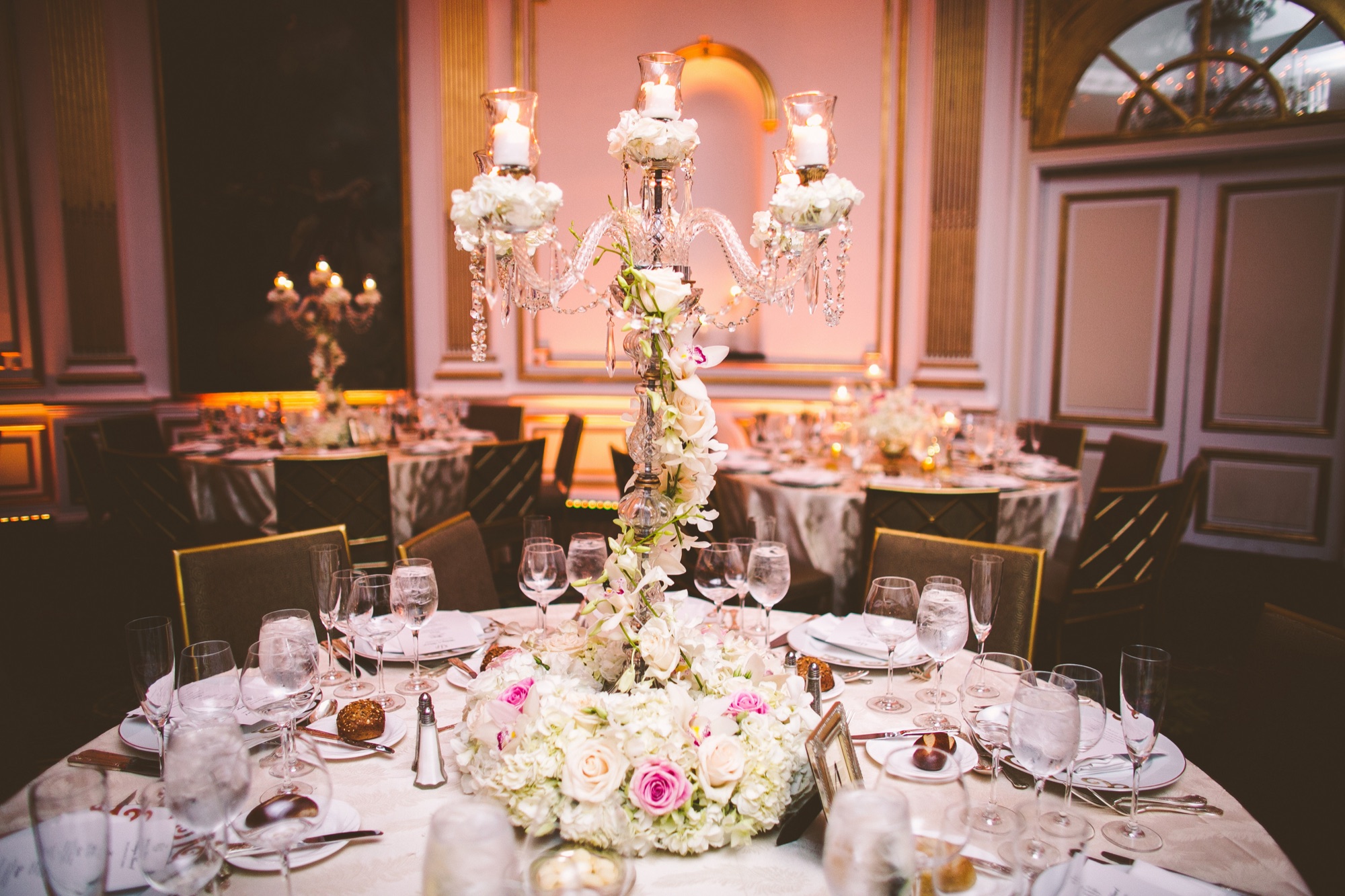 Tall floral centrepieces and candelabra above the reception tables