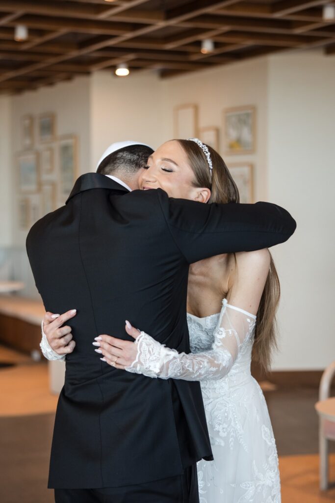 The couple holding each other in the hotel lobby moments after their first look