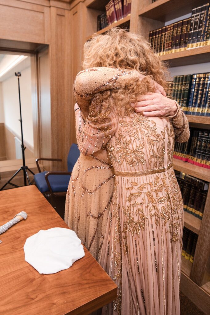 The two mothers holding each other after the plate is broken