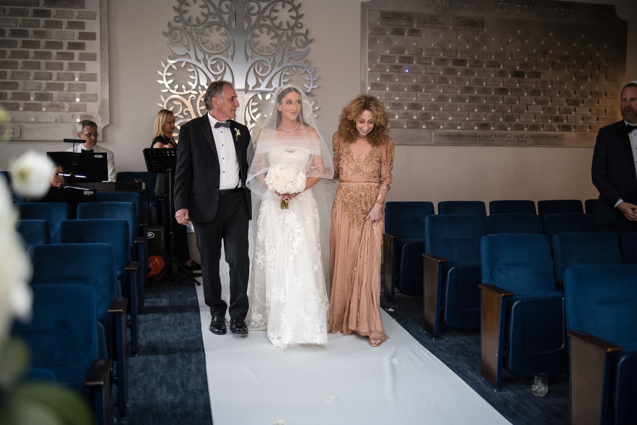 A bride entering her Jewish wedding ceremony with family