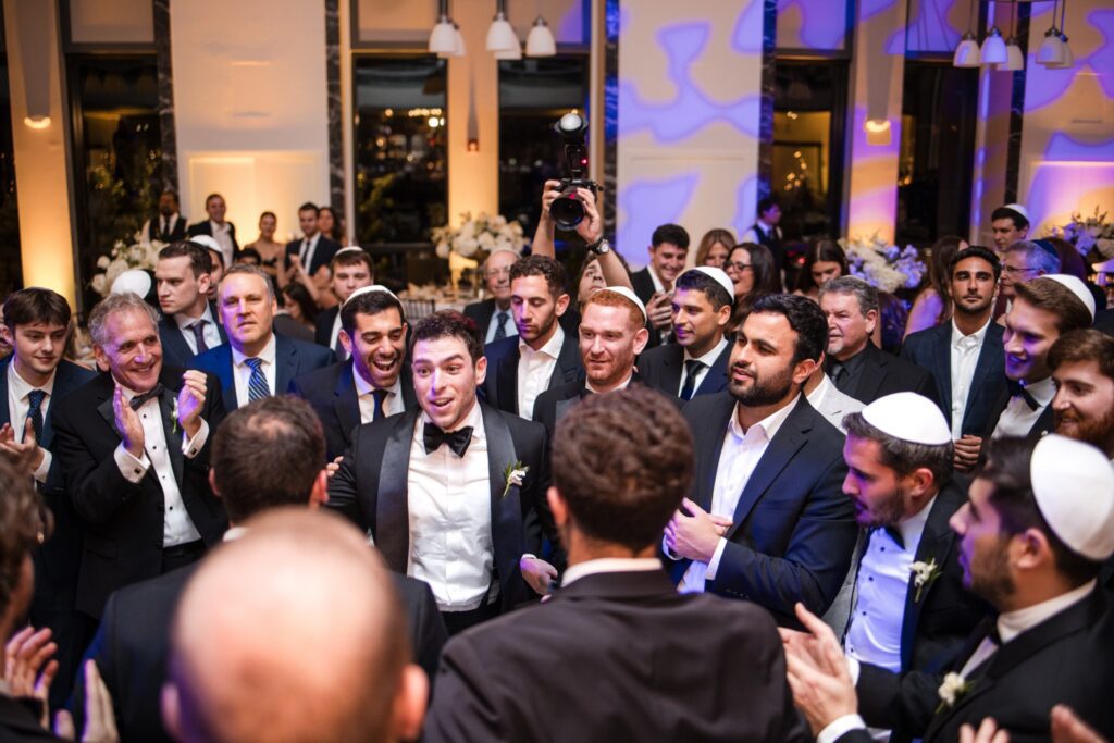 The circle closing around the groom during the hora
