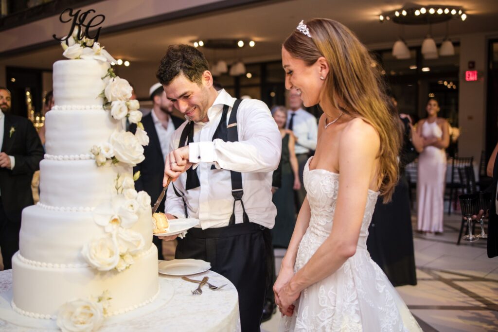 Kinneret and Gordon cutting the white tiered cake