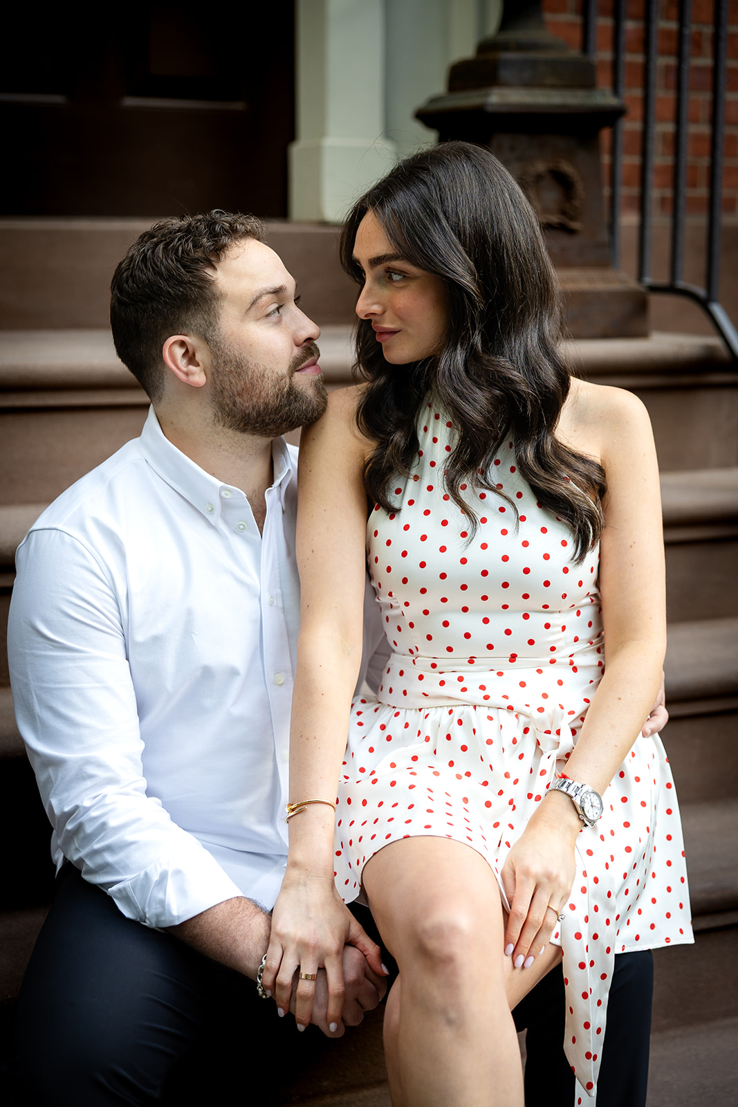 Couple sitting close together during a West Village engagement session.