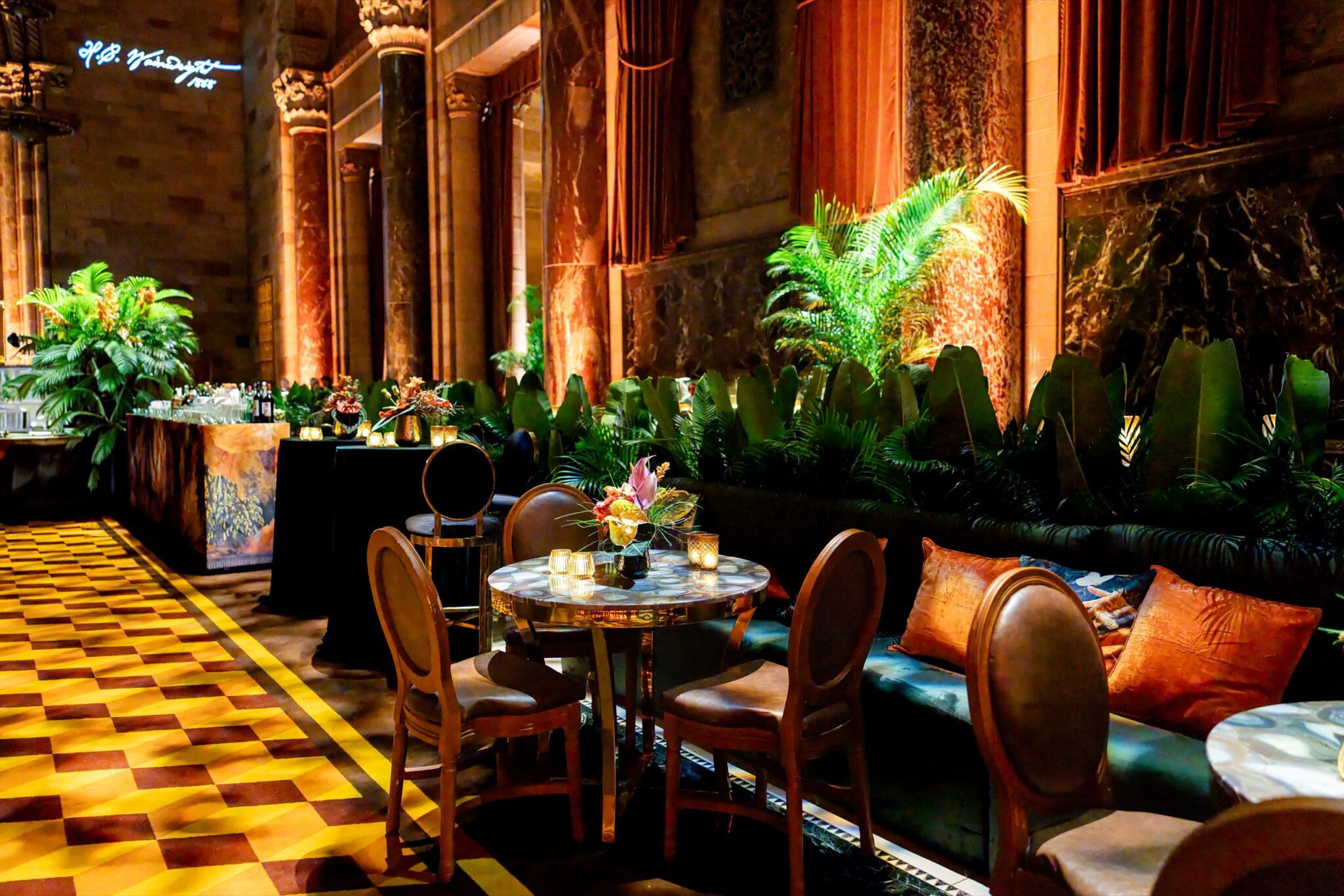 Cocktail tables and tropical greenery arranged along the Cipriani stone columns