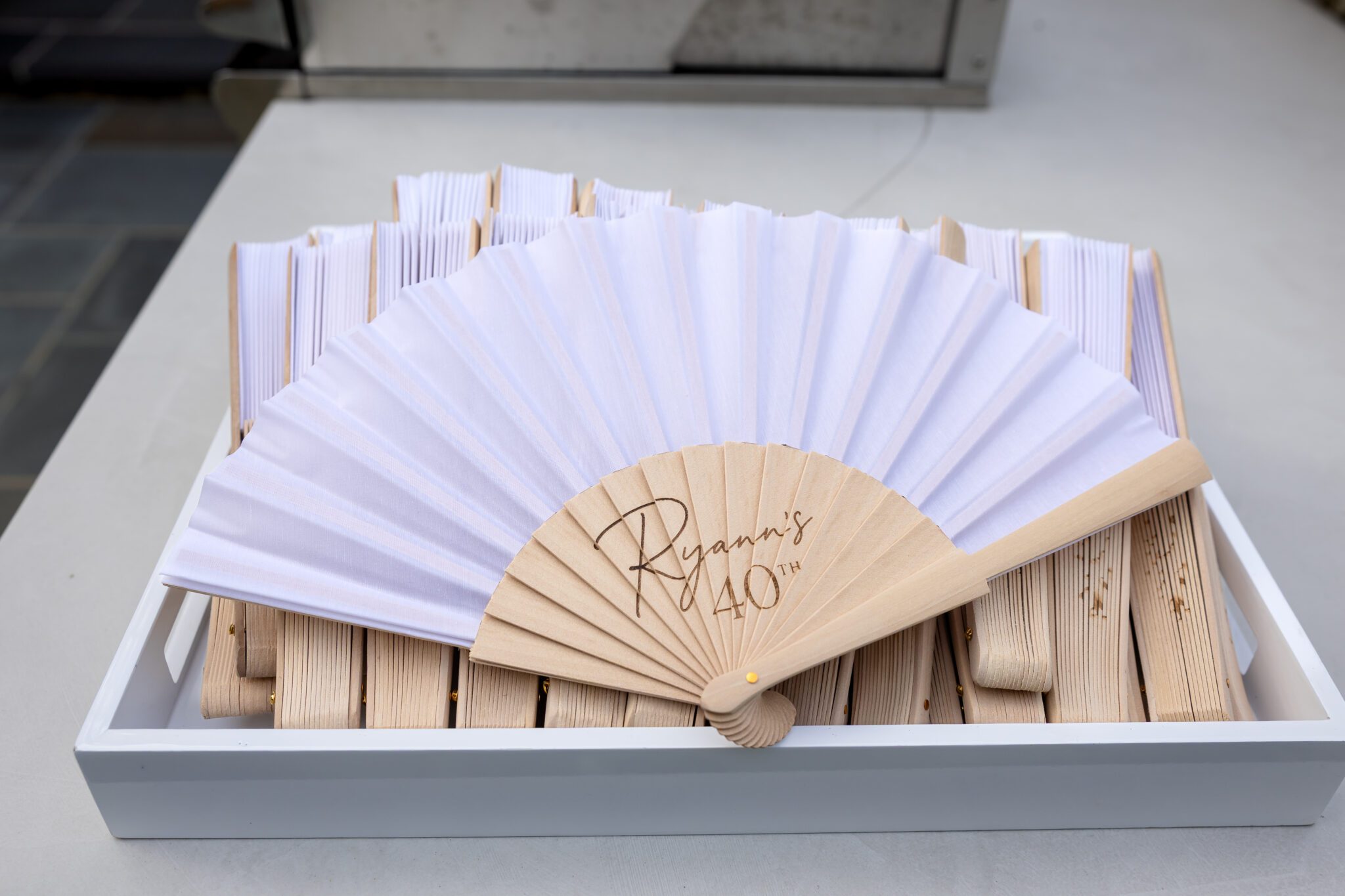 Personalized white fans arranged for Ryann's 40th birthday guests