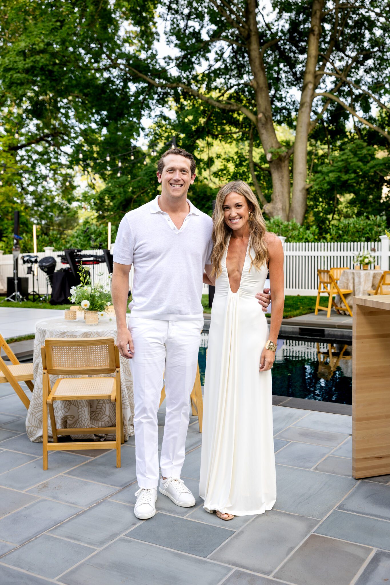 Birthday honoree and guest photographed beside the pool before arrivals