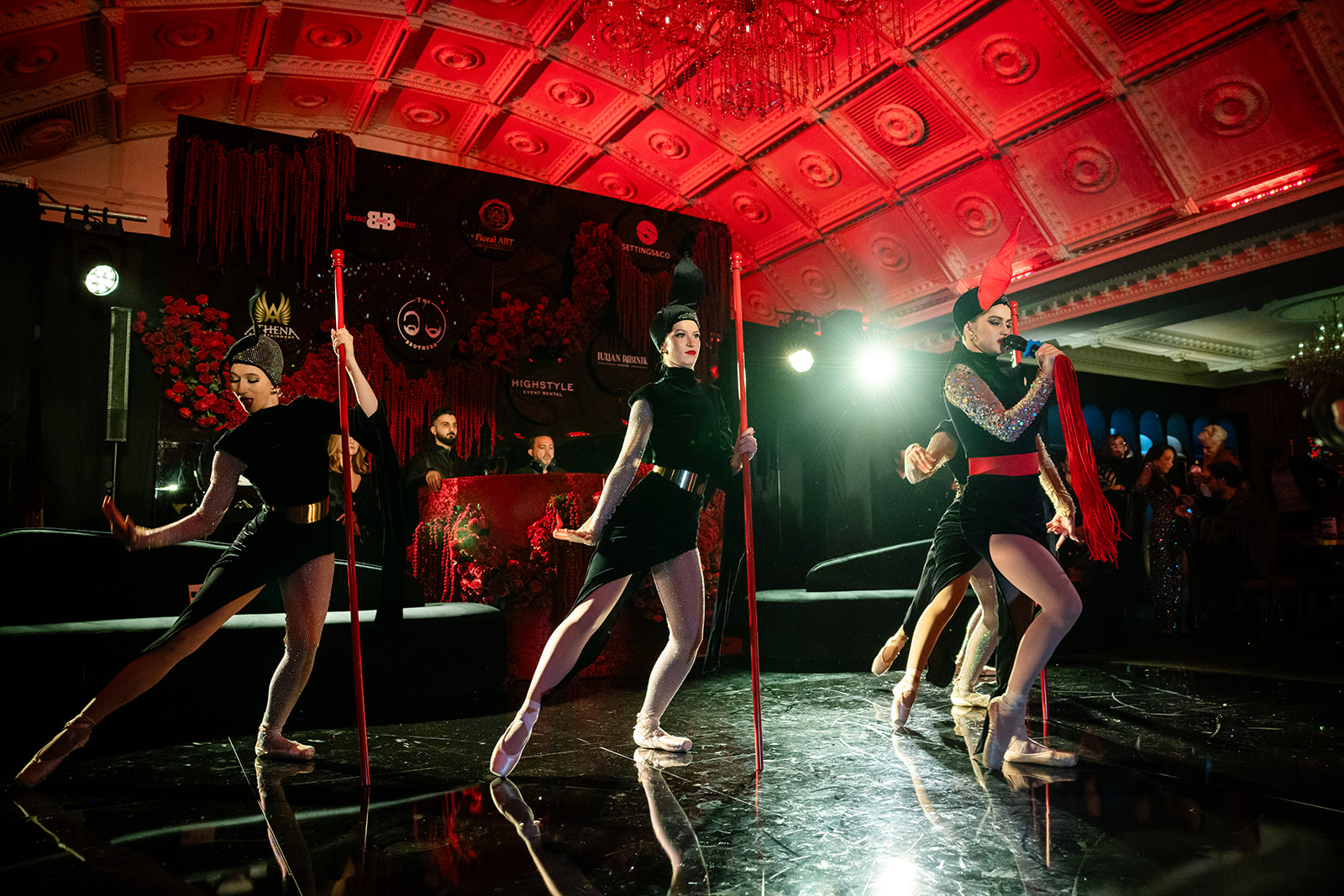 Wide stage performance beneath the red-lit ballroom ceiling