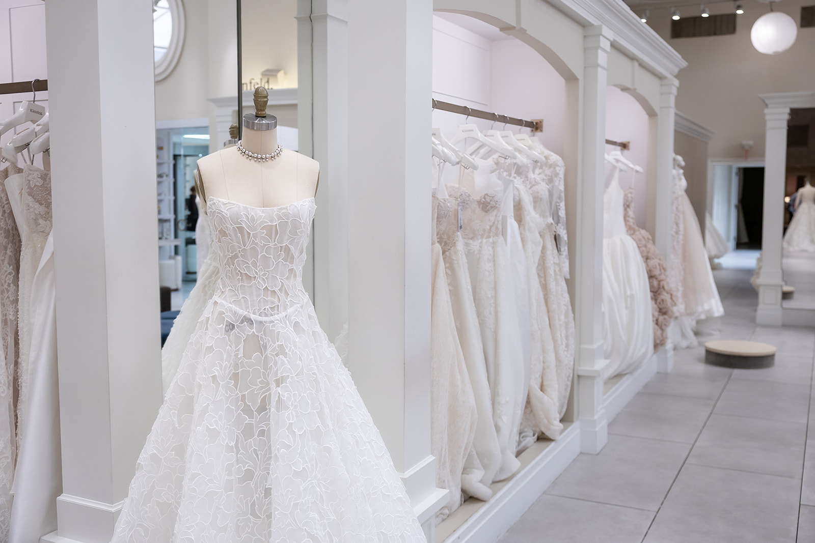Nicole and Felicia bridal gowns arranged on a rack at Kleinfeld
