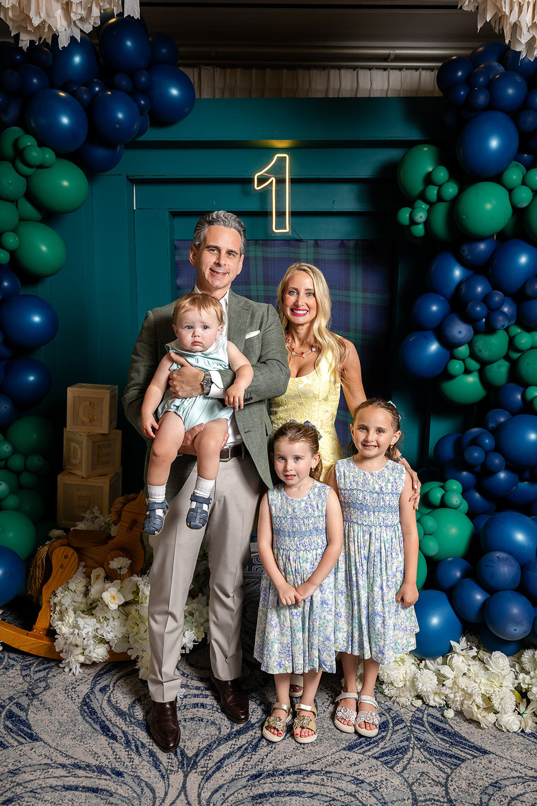 Family portrait at a blue and green teddy bear first birthday party
